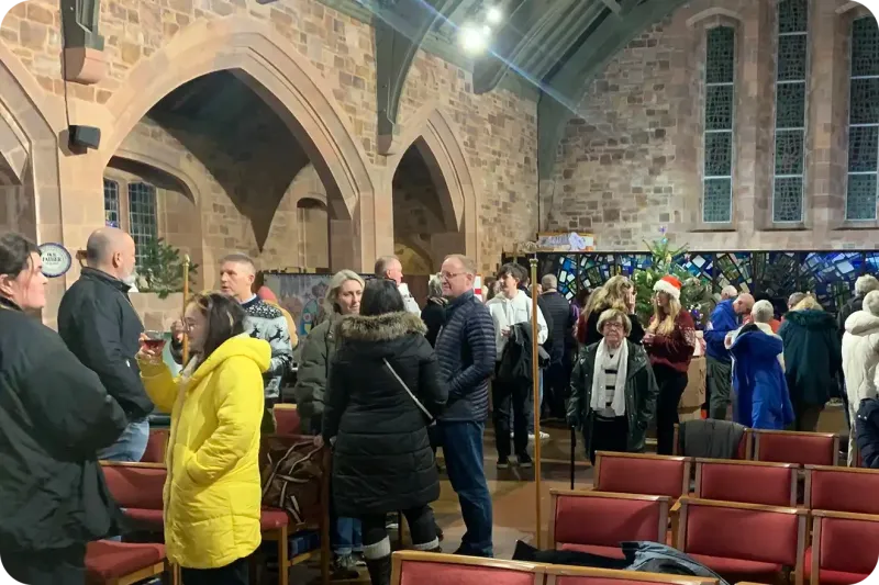 Members of the congregation standing at t he back of the chuch enjoying a drink and a chat.
